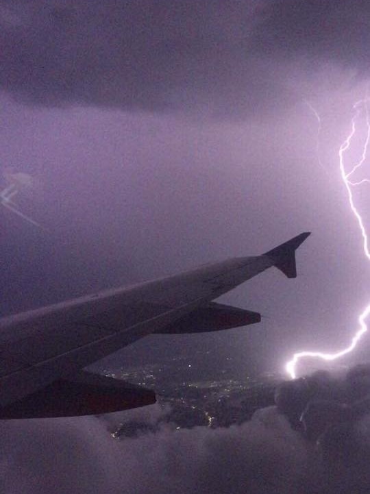 A lightning strike can be seen out the window of a plane landing in Brisbane.