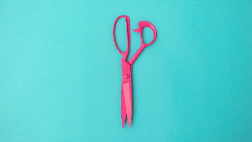 A pair of pink scissors on a blue background