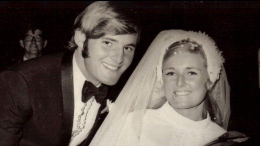 Black and white photo of man and woman dressed in wedding atire.