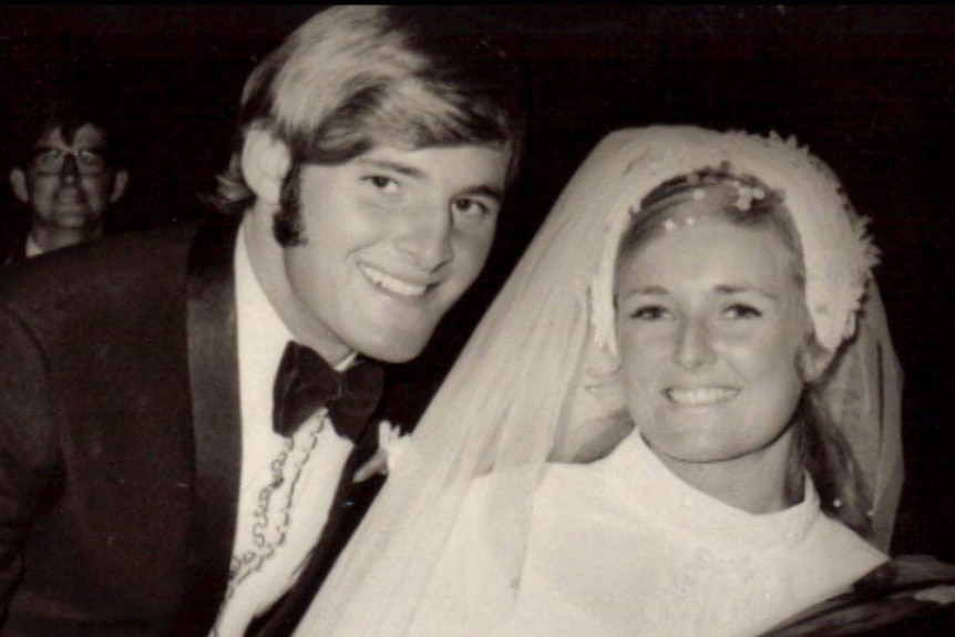 Black and white photo of man and woman dressed in wedding atire.