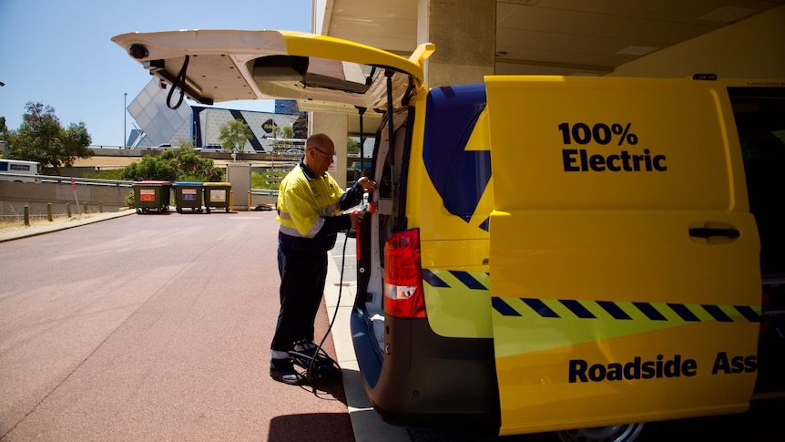 An RAC worker looking into a yellow roadside assistance van
