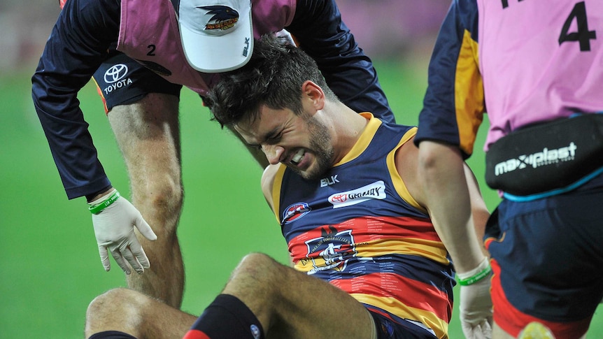 Injury blow ... Taylor Walker receives treatment during the defeat to the Hawks