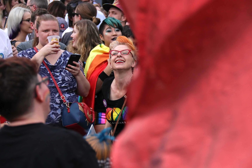 A woman dances in a crowd.