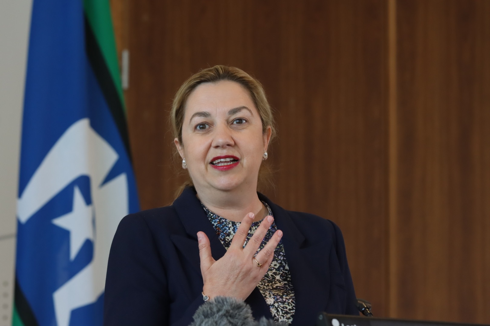 premier gesturing as she speaks, behind a lecturn 