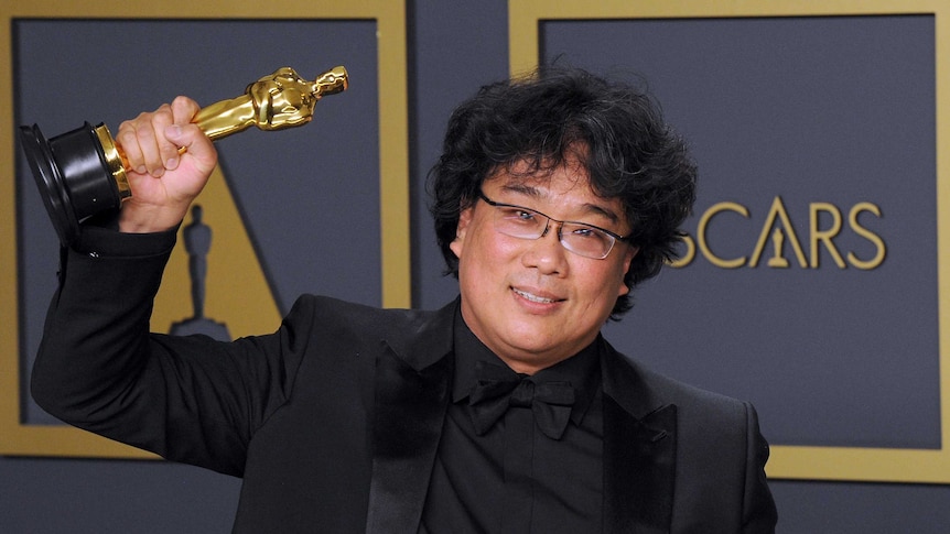 Oscar winning director Bong-Joon Ho holds up two of his Oscar statues