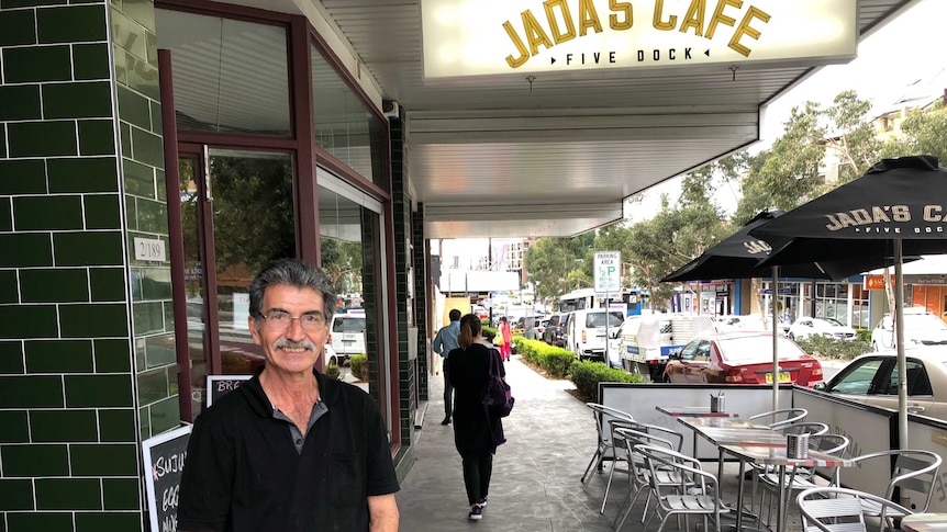 Harry standing in front of his cafe.