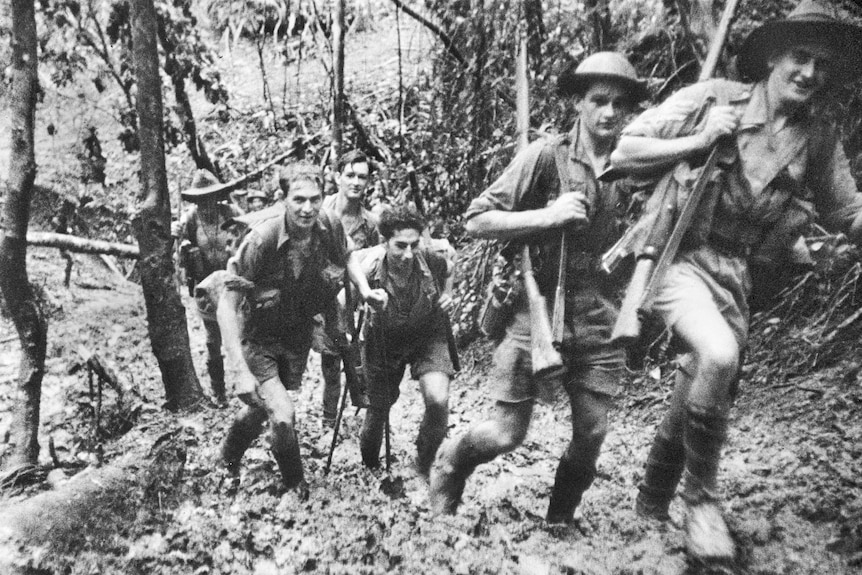 Soldiers marching up a hill in a photo by Damien Parer