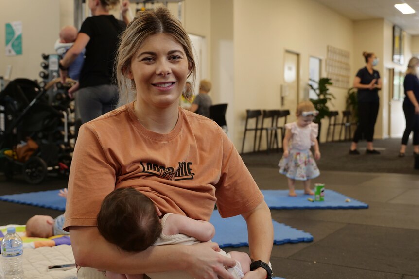 New mum Elysse breastfeeds her baby at the gym.