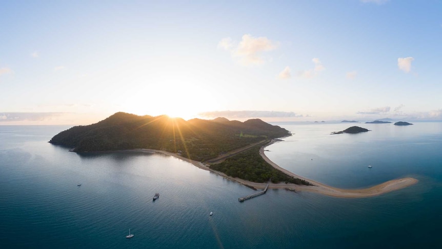 Sun rising behind island