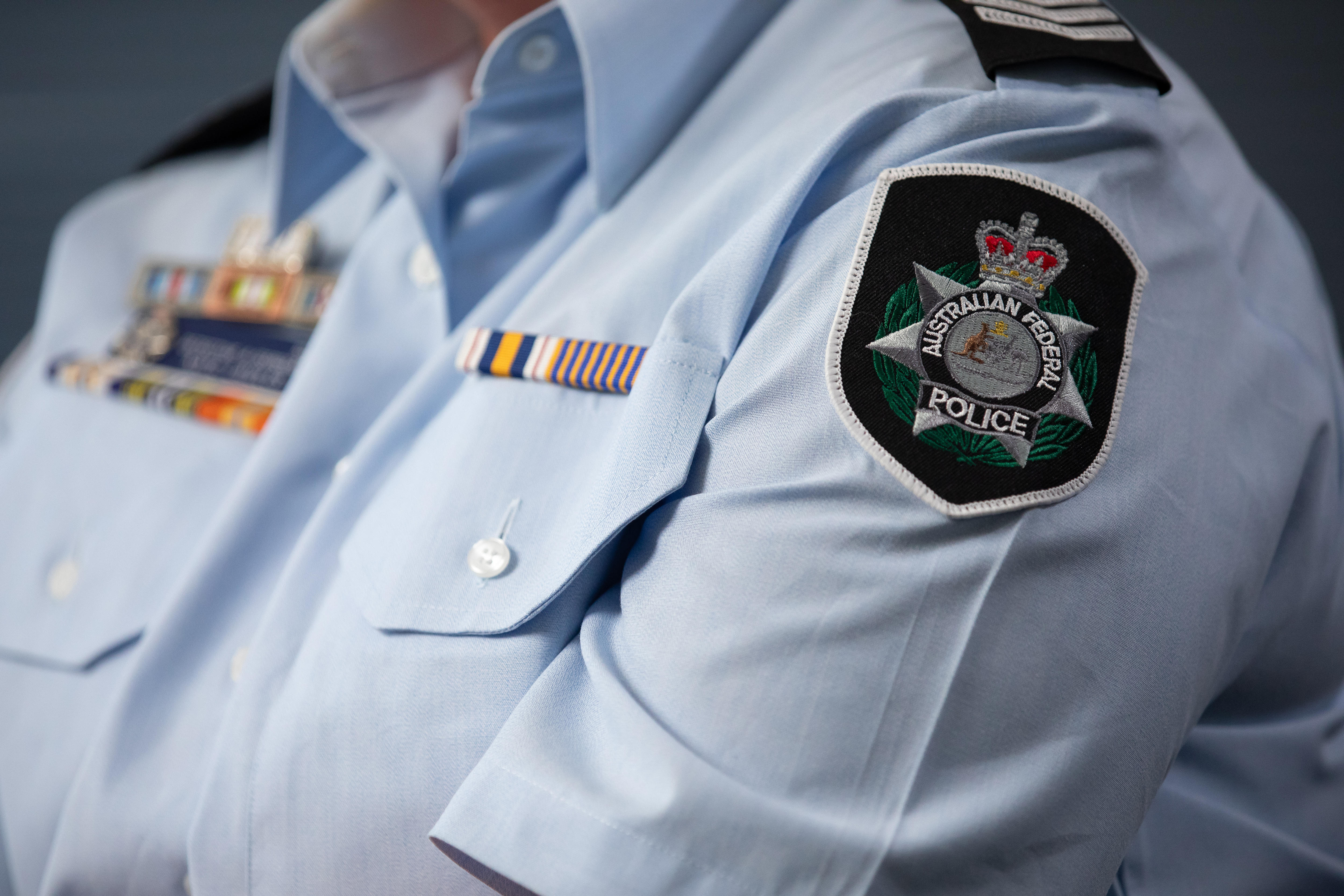 A female police officer's uniform showing rank and ribbon bars.