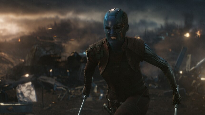 Colour still of Karen Gillan as Nebula in aggressively moving forward on battlefield in 2019 film Avengers: Endgame.