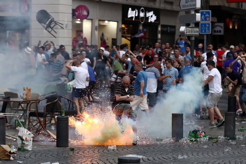 A tear gas canister explodes under a football fan as England fans clash with police in Marseille