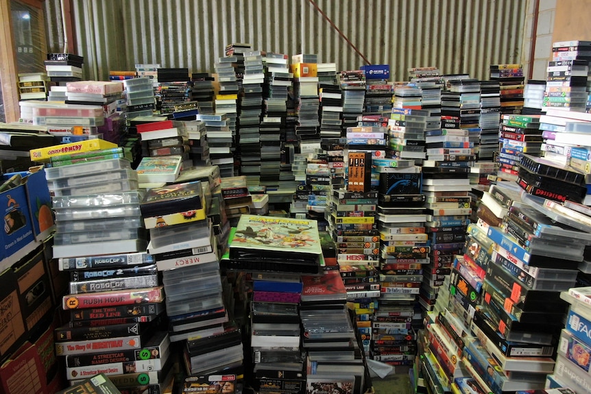 Dozens of piles of video tapes in a warehouse
