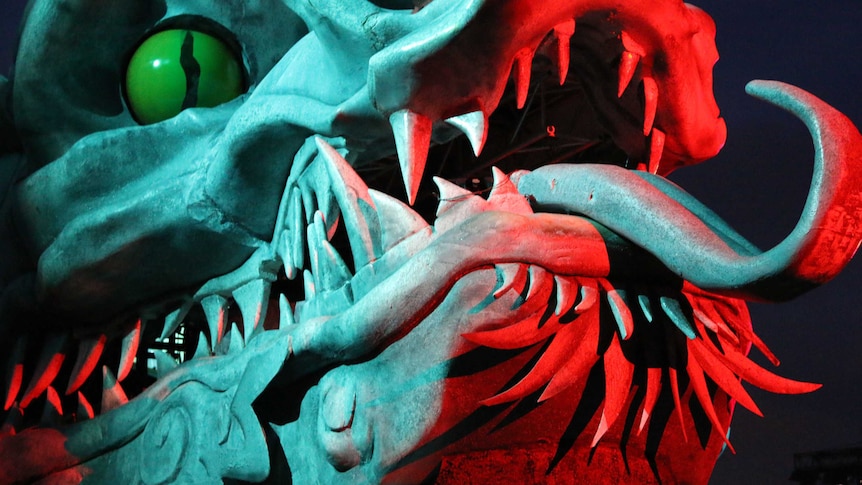 A massive dragon with green eyes and sharp teeth that is part of the production of the Opera Turandot on Sydney Harbour.