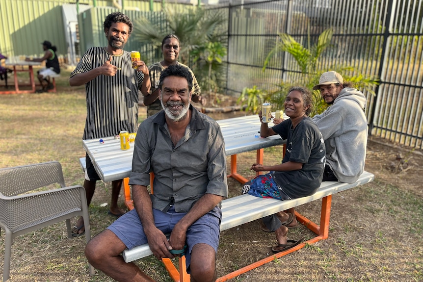 a group of aboriginal people smiling, drinking beer at a social club
