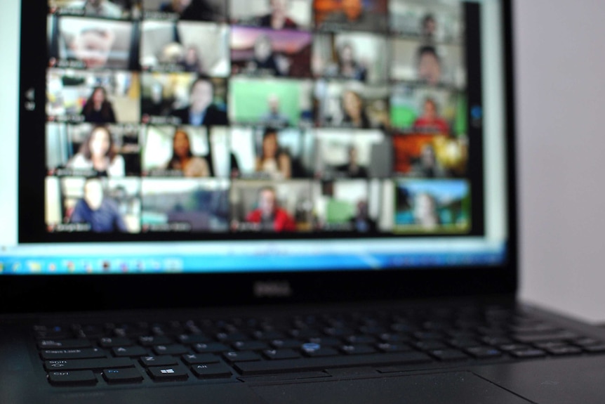 A video conference call on a laptop with at least 20 different participants.