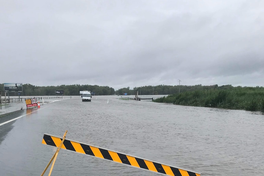 a car drives through flood waters on the Bruce Highway south of Proserpine