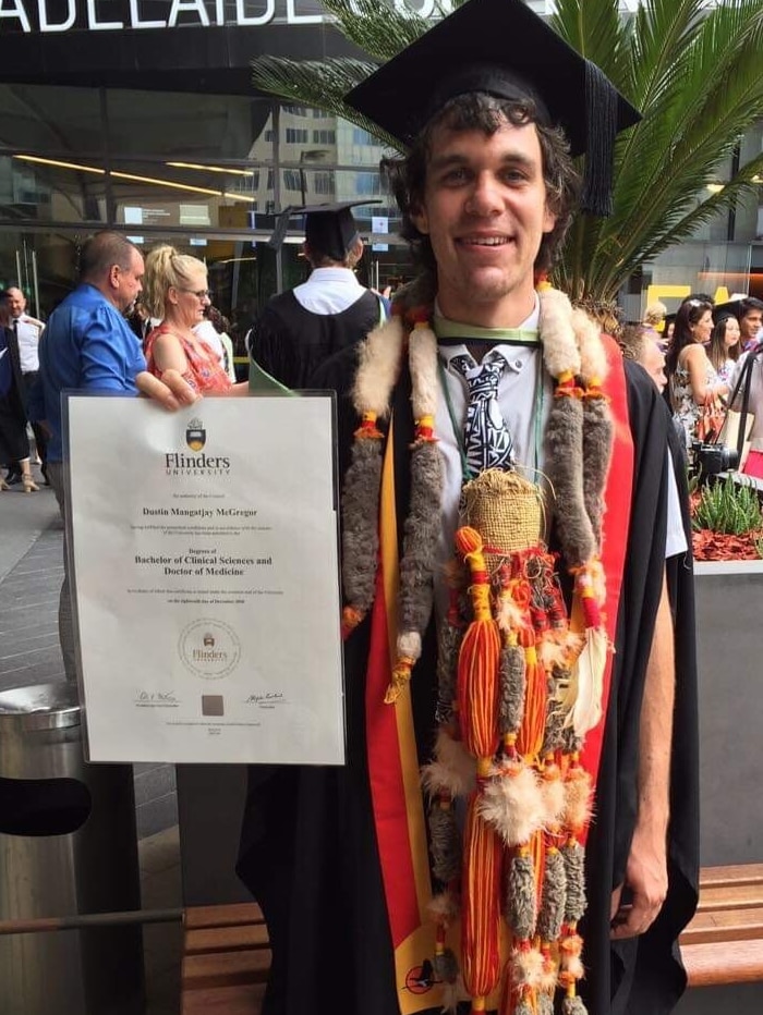 Mangatjay McGregor wears Yolngu adornments over his graduation robes