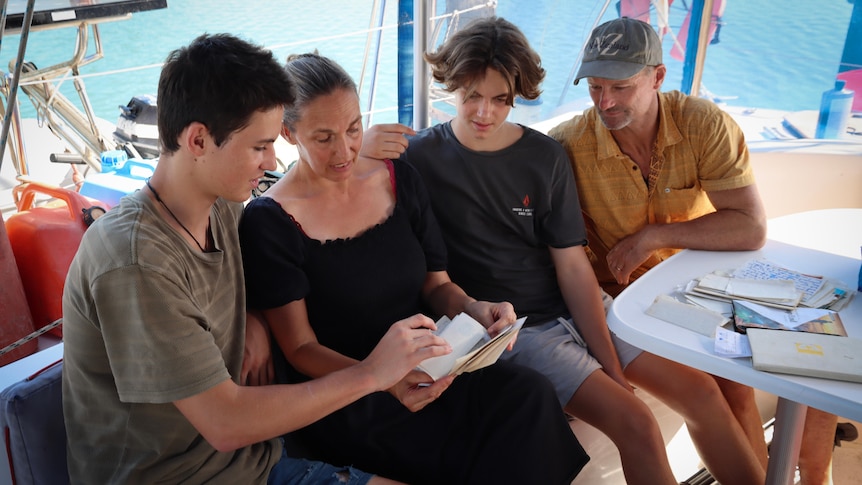 A family looking through letters on a boat.
