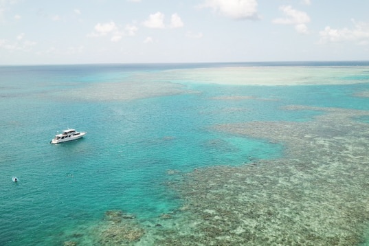 Aerial photo of Ellison Reef and a boat on the Great Barrier Reef in north Queensland
