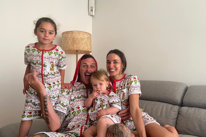 two children man and woman in matching christmas pj's smiling 
