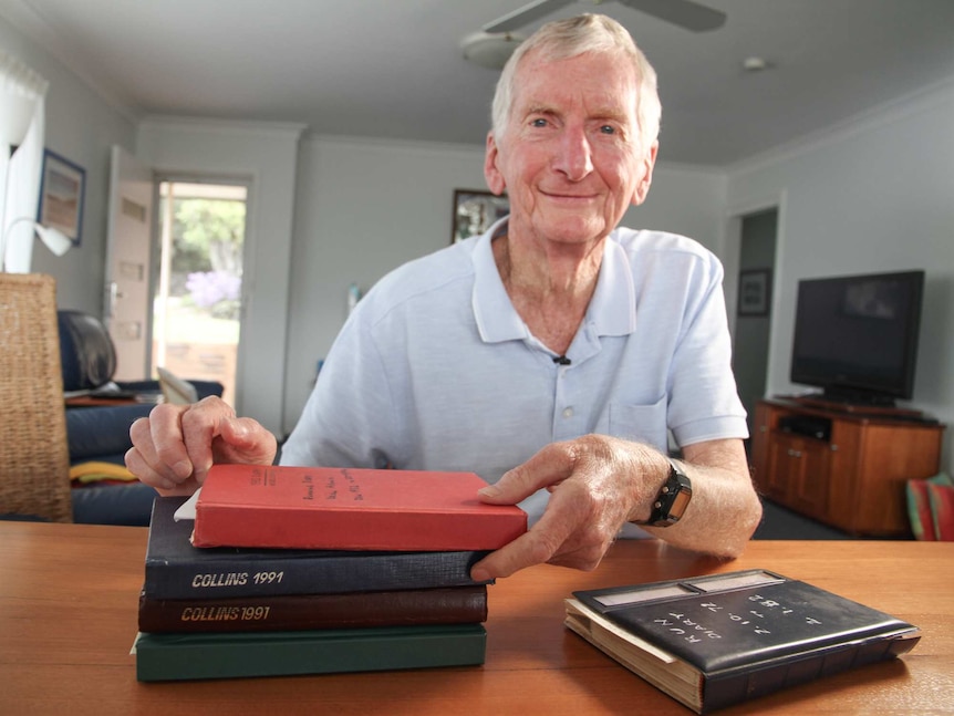 A man with old diaries on a table