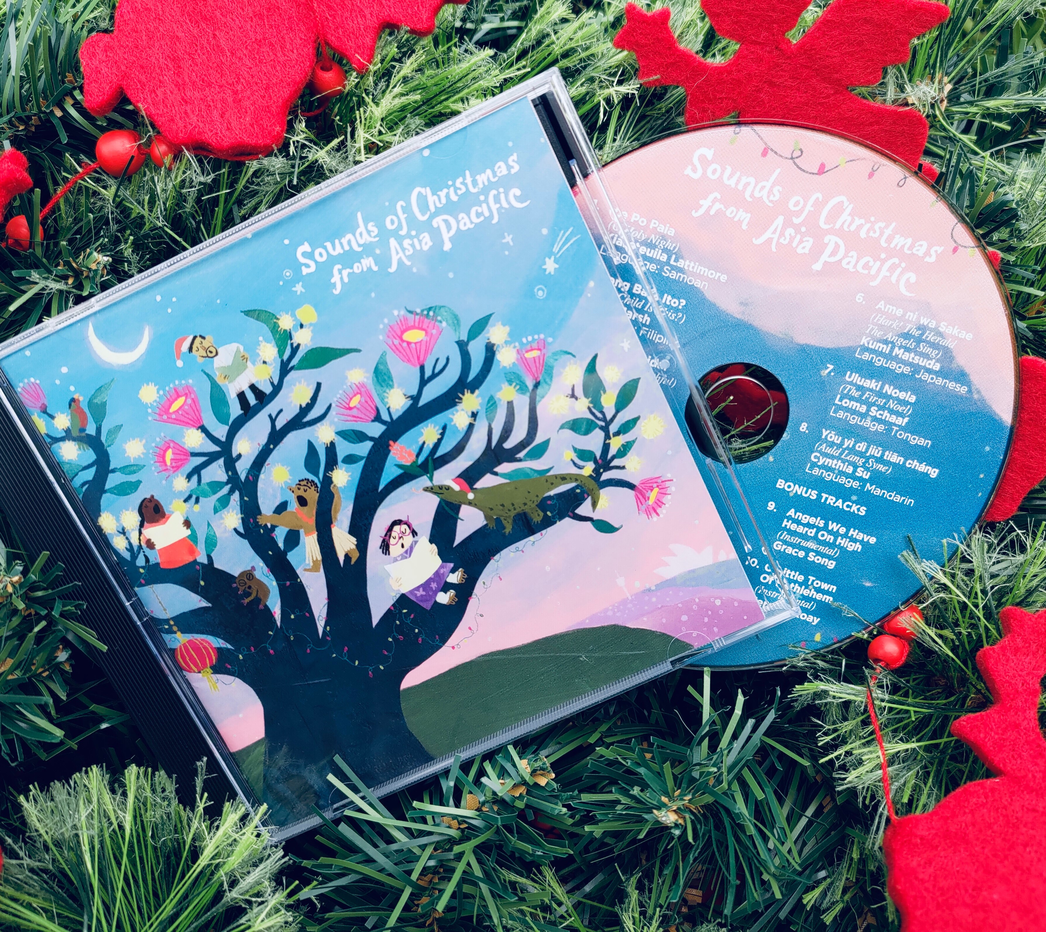 A pink CD pictured on a Christmas tree with a red background