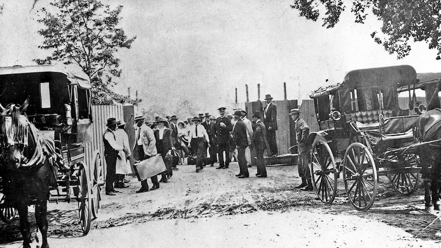 People from the past gather together in a black and white photograph.