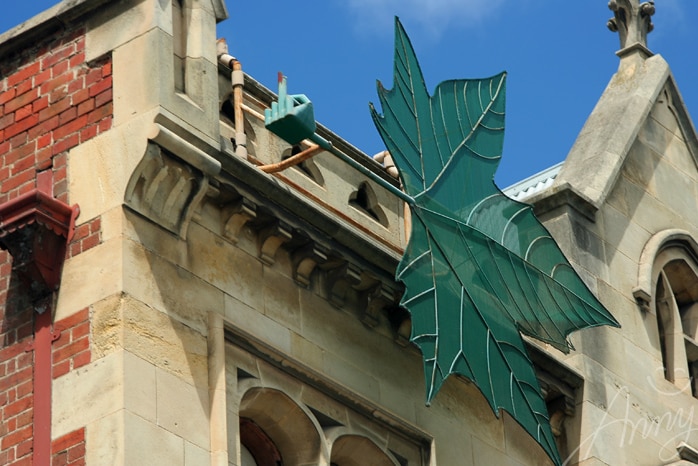 Image of sculpture of hand with middle finger on top of a ledge on an old building