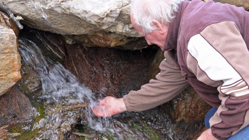 Peter Andrews drinks from a creek at Mulloon Creek Natural Farms.