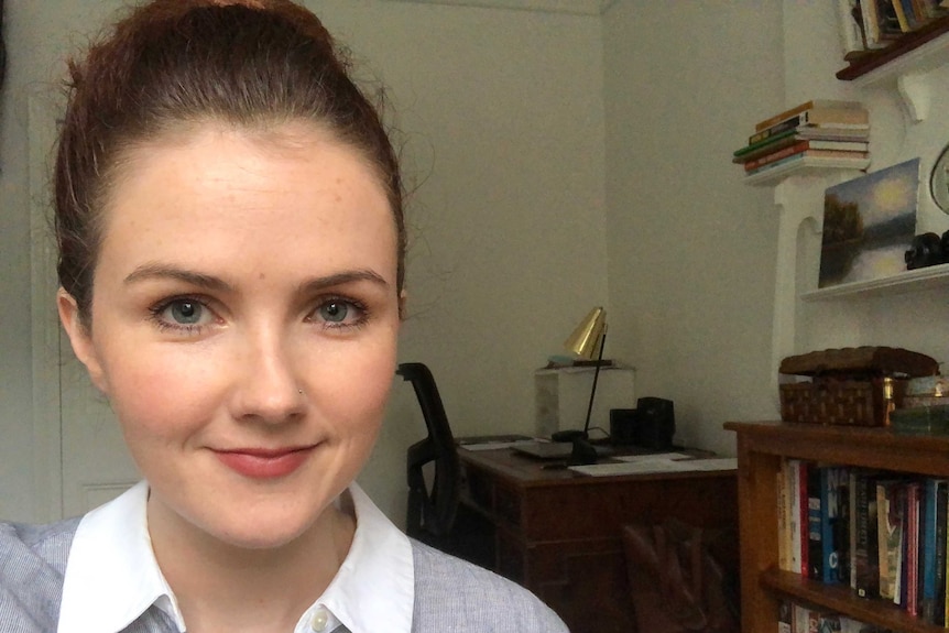 A woman with dark hair in a home office.