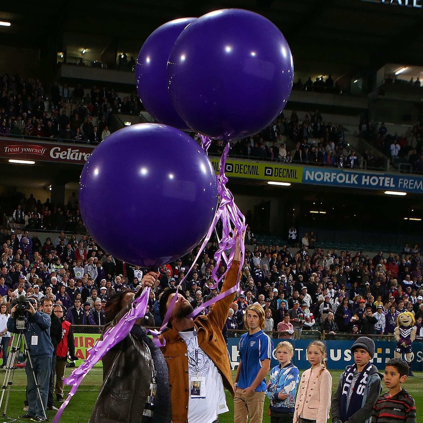 Marite Norris and Anthony Maslin, parents of MH17 crash victims Evie, Mo and Otis Maslin release balloons at Paterson's Stadium.