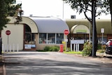 A building with a bullnose roof and stop signs out the front