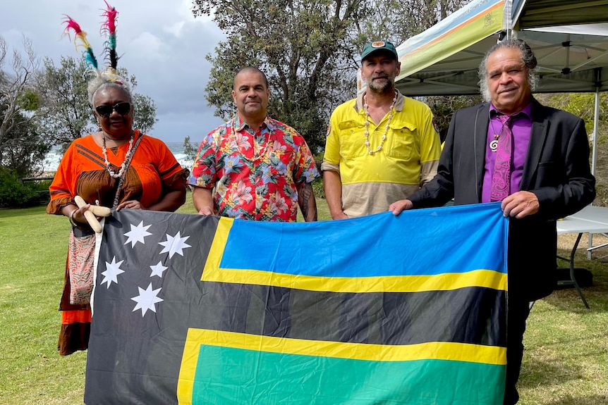 Four people holding a flag.