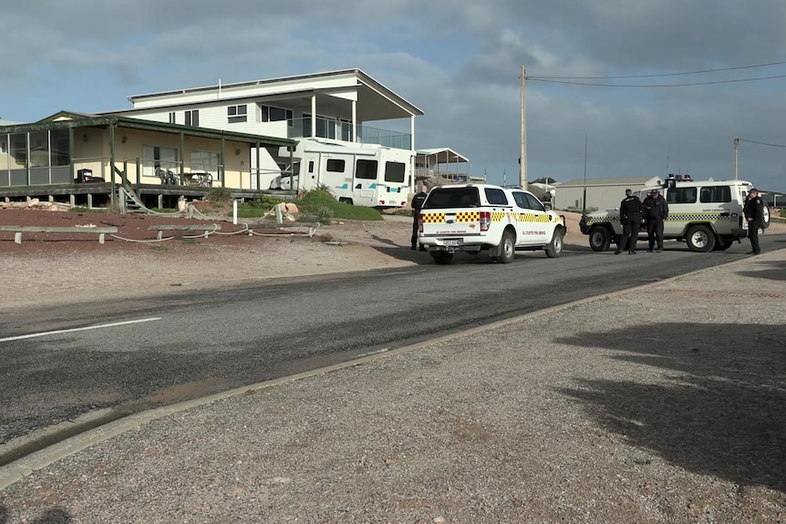 Police and an SES vehicle outside a holiday house with a motorhome