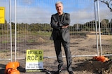 Steve Portelli stands against a wire fence where land had been cleared for the Roe 8 project.