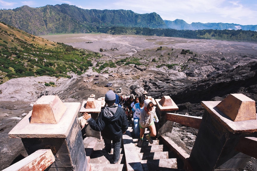 People climb and go down steep stairs.