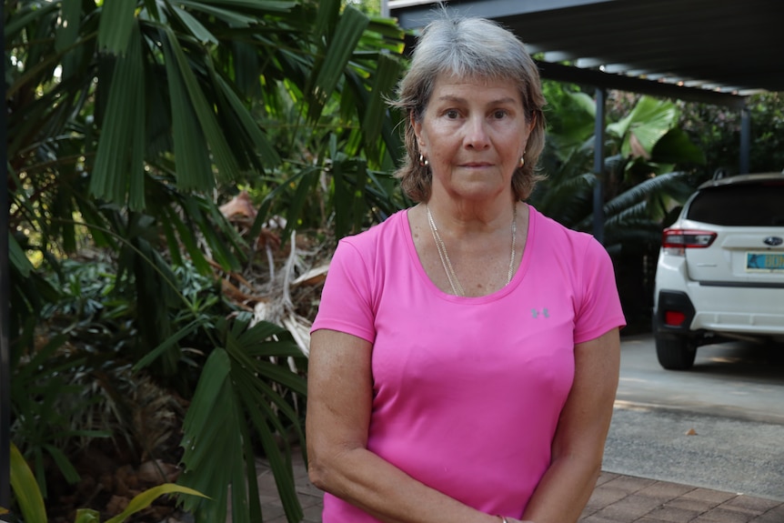 a woman with silver hair wearing a pink shirt