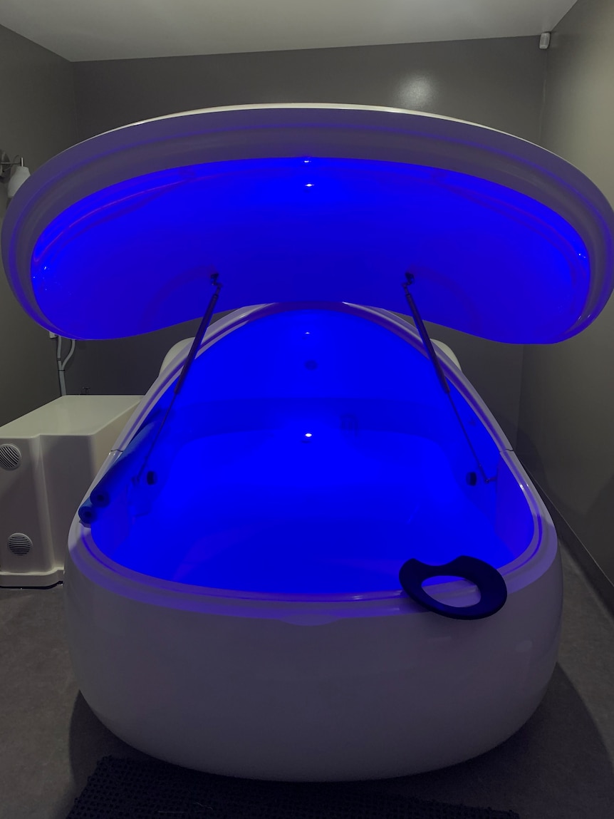 A white sensory deprivation pod with blue-lit water inside. For a story on floatation therapy. 