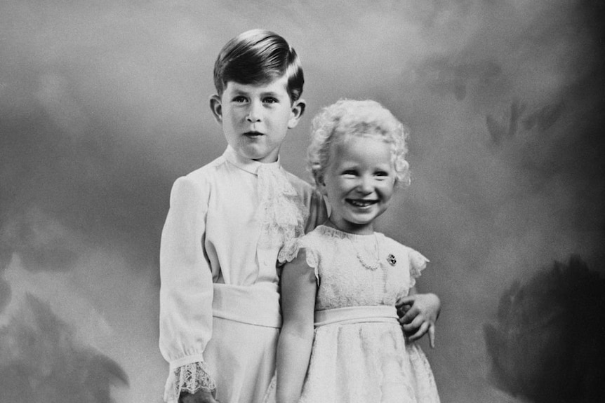 A black and white photo of a little Prince Charles and Princess Anne standing together