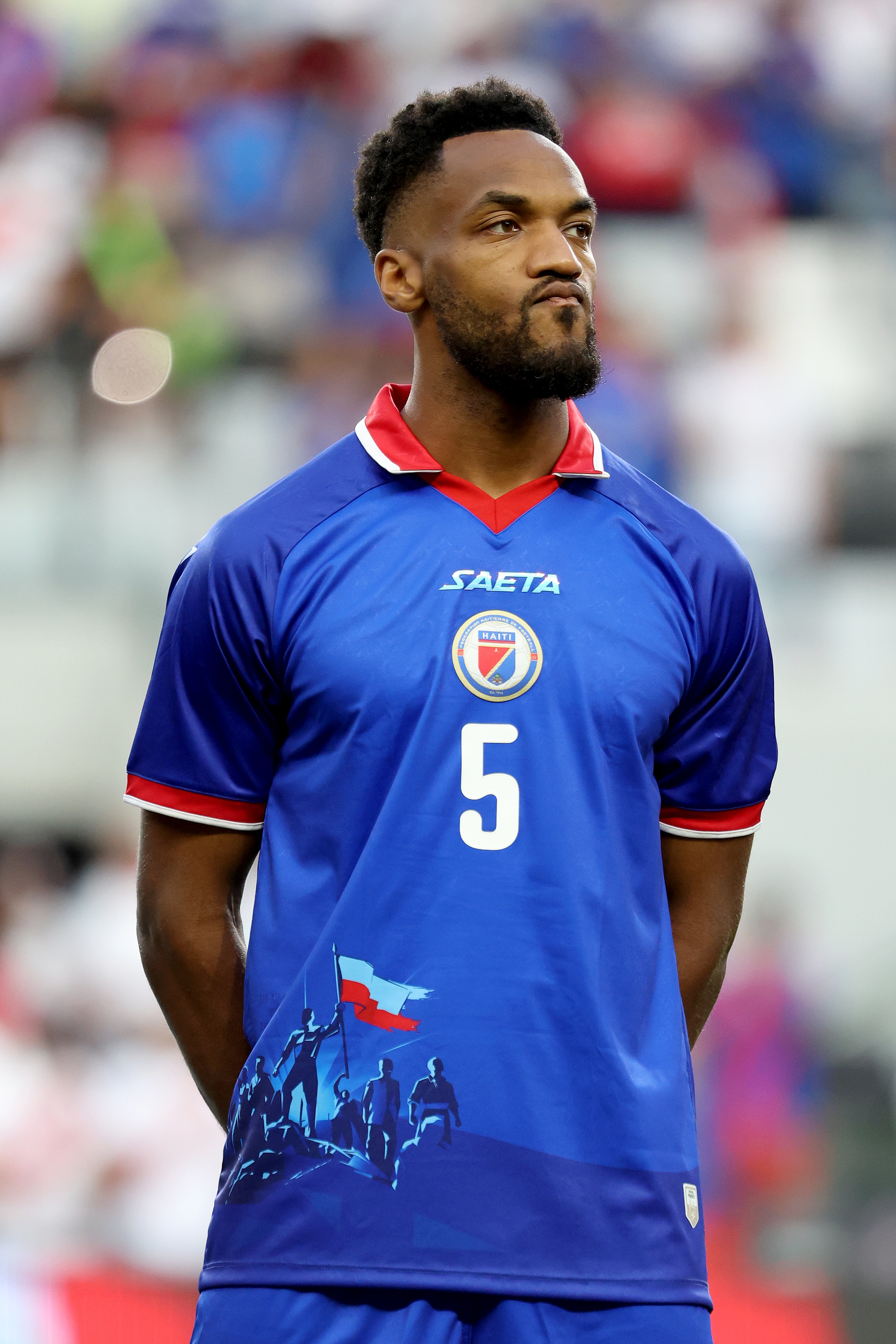 O jogador de futebol haitiano Hannes Delcroix usa camisa proibida pela FIFA