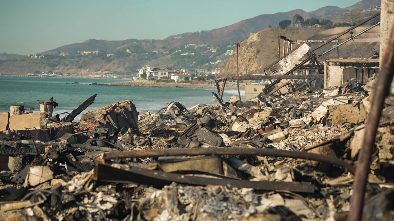 Beach front properties are burned into a pile of rubble on the coast line