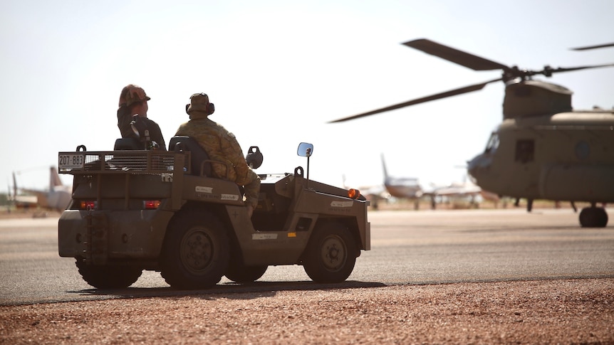Australian Defence Force personnel sitting in a vehicle on the tarmac at Broome Airport.