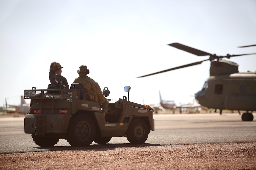 Australian Defence Force personnel sitting in a vehicle on the tarmac at Broome Airport.