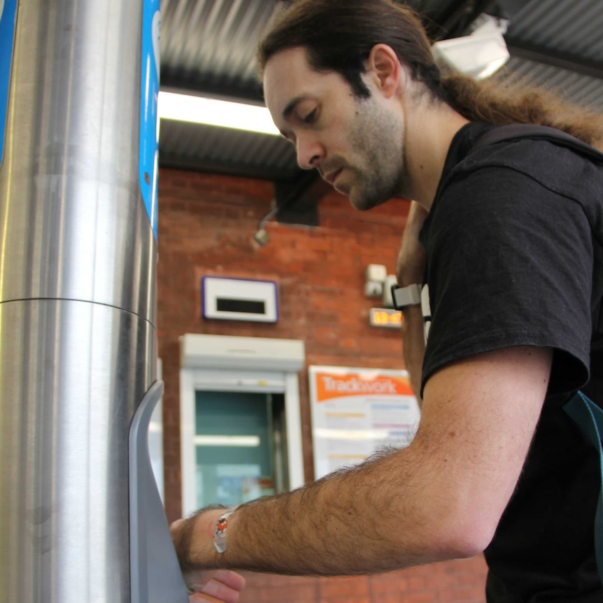 A man using his arm to swipe on public transport.