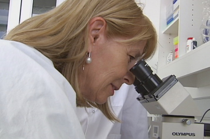 Professor Elizabeth Rakoczy looking into a microscope in Perth in macular degeneration study