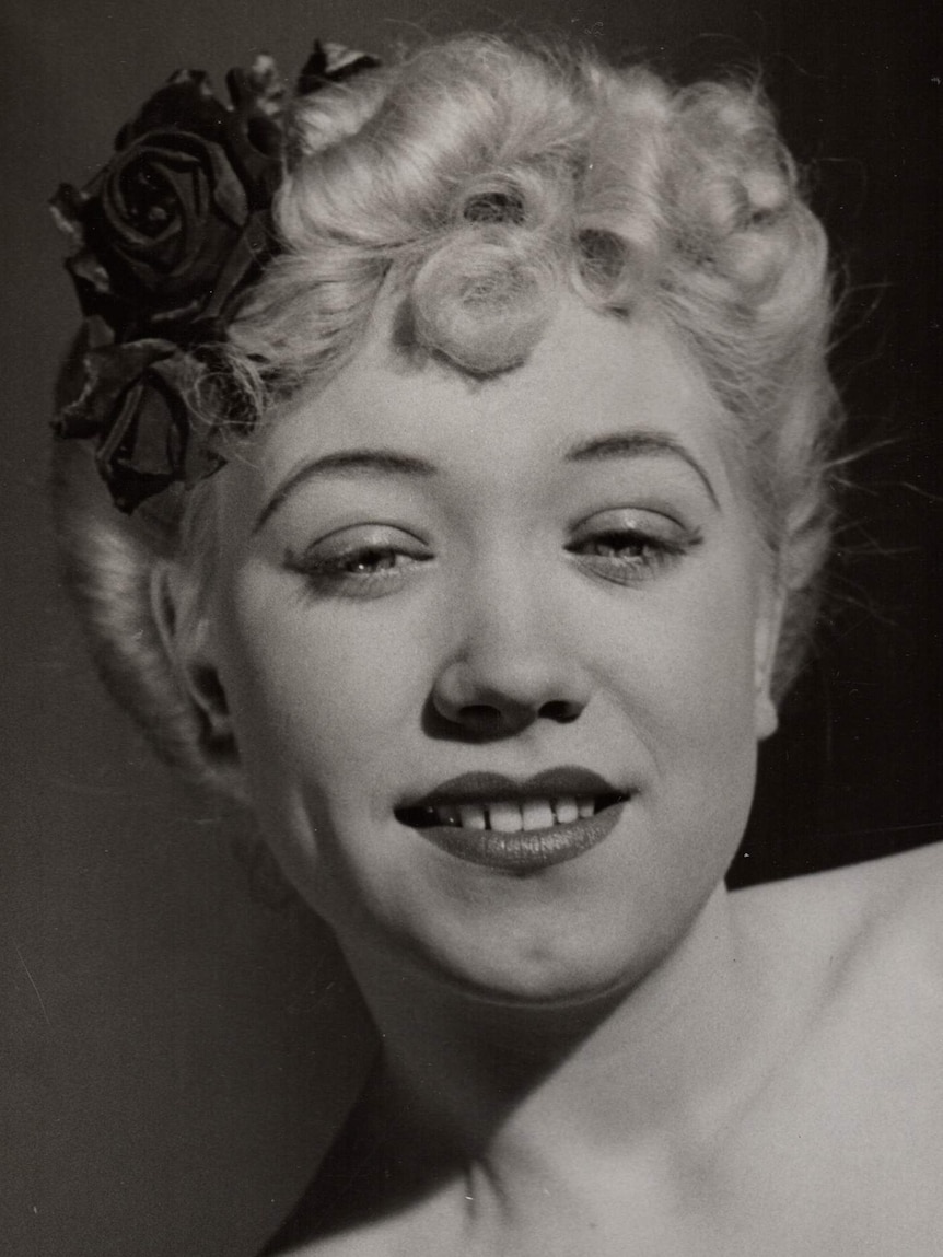 A platinum blonde young woman in a black and white glamour shot.