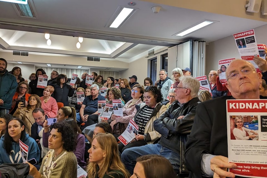 a crowd of people holding posters reading "kidnapped"