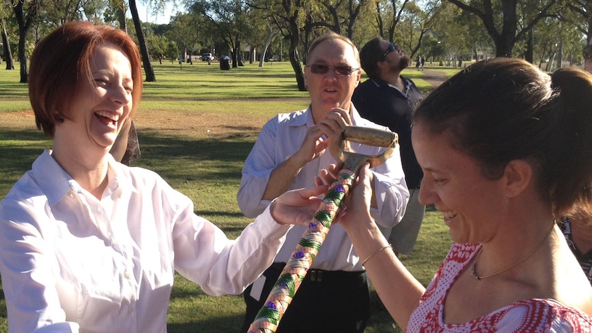 Julia Gillard and Emily Bolto admire a hand painted shovel in Kununurra