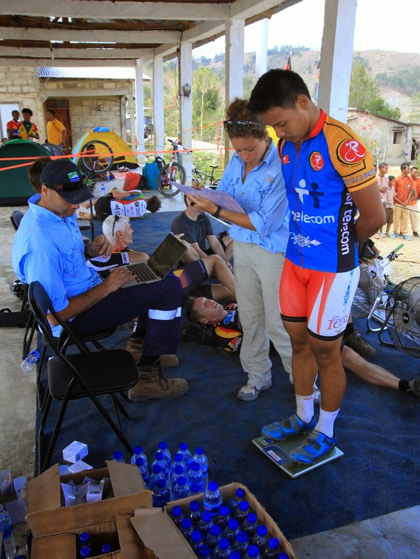 A Tour de Timor competitor completes the weigh-in, under official scrutiny.